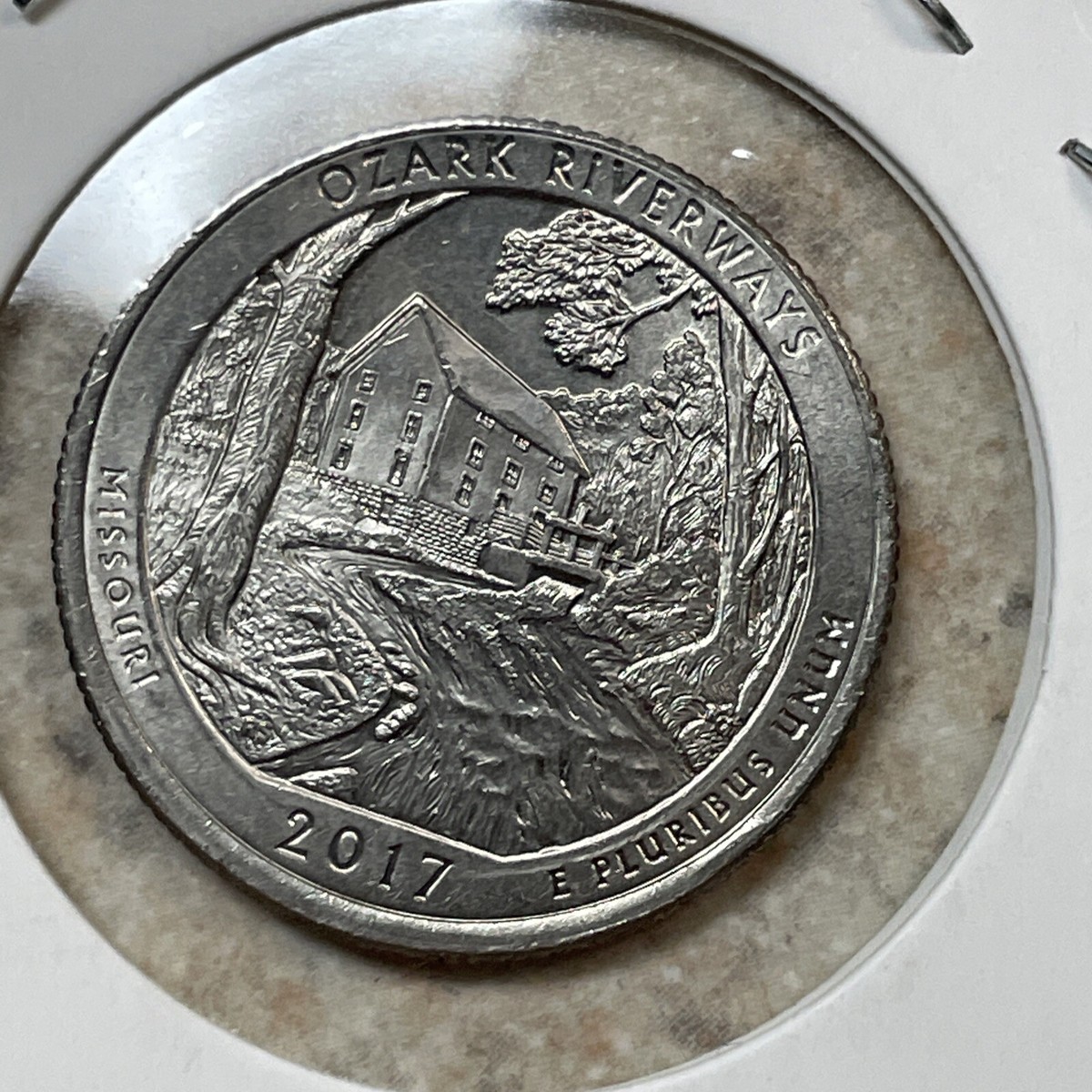2017 quarter off-center strike error — design shifted to one side with visible crescent of blank metal on opposite edge